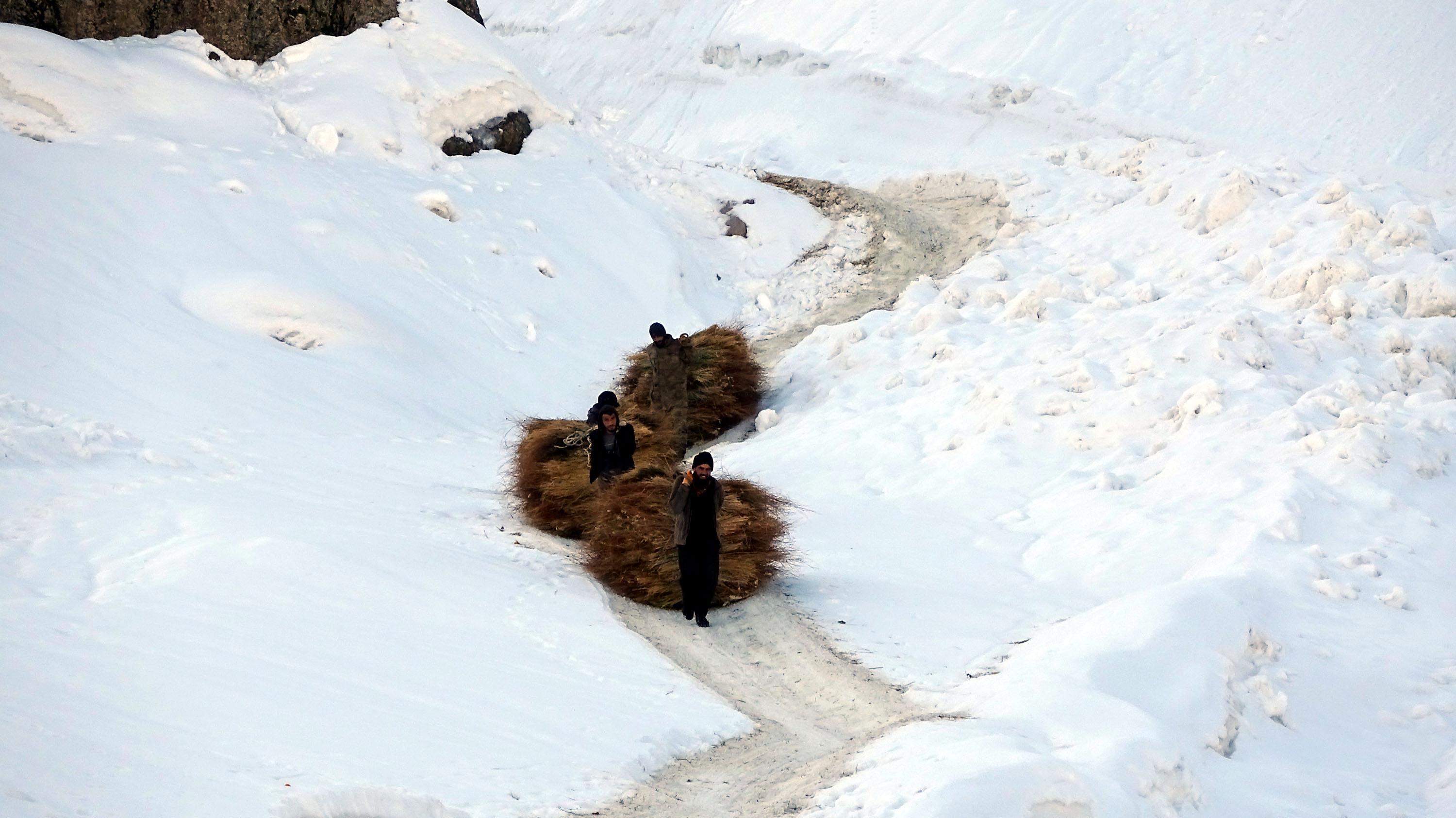 Villagers transport hay bales to the village by zipline
