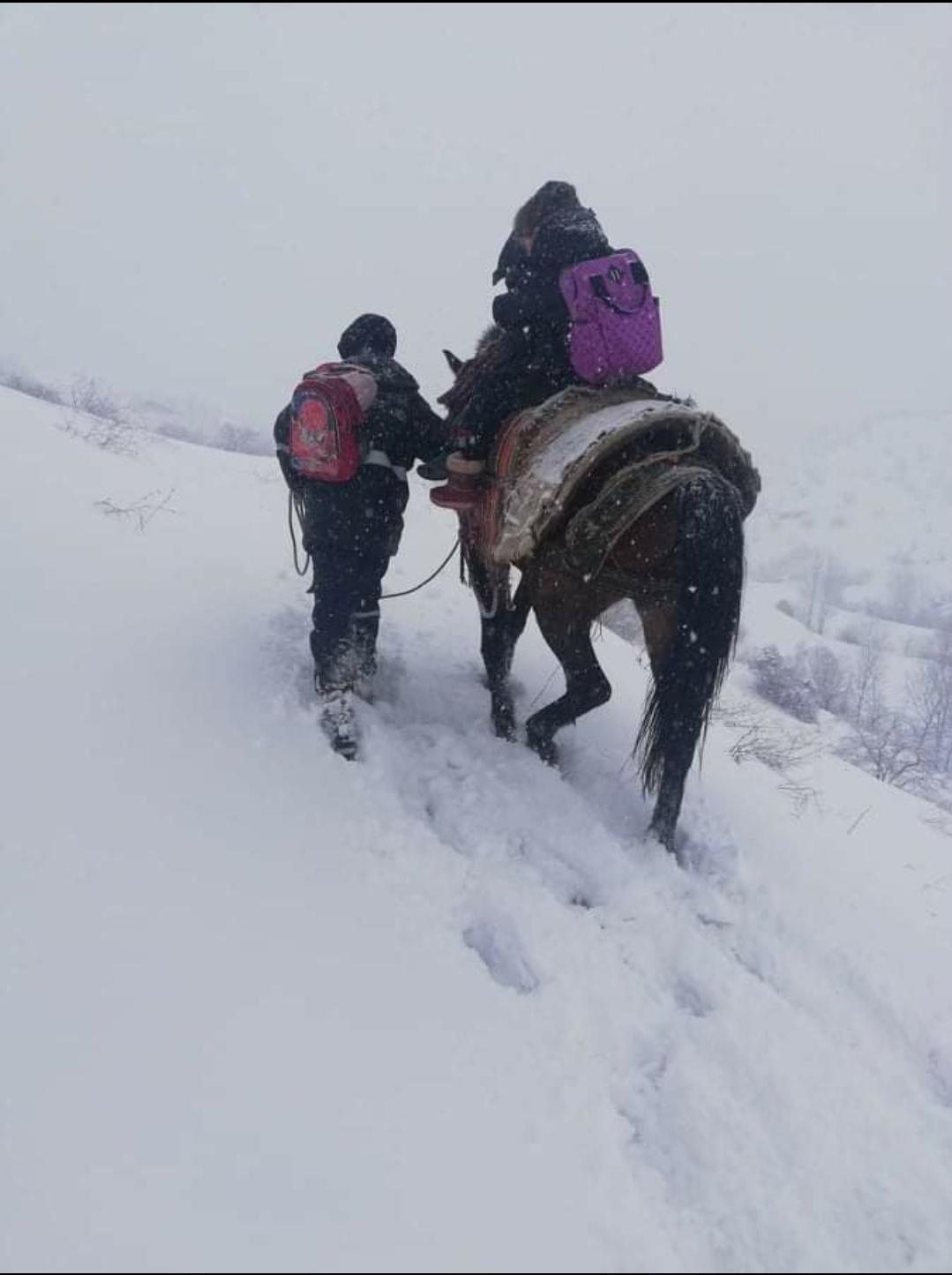 Kar yolu kapatınca, çocukları at sırtında okula götürdü
