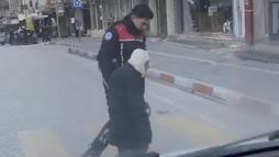 Yolun karşısına geçmekte zorlanan yaşlı kişiye polis yardım etti