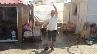 Hatay'da sıcak havalardan bunalan vatandaş çadırların önünde suyla serinledi
