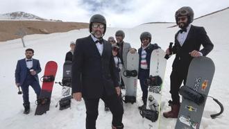 Takım elbise, kravat ve papyonla snowboard