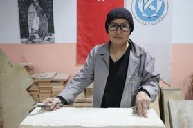 Hat sanatı hocası, tarihi Rum Yetimhanesi'nin bahçesinde kurulan atölyede taşa şekil veriyor