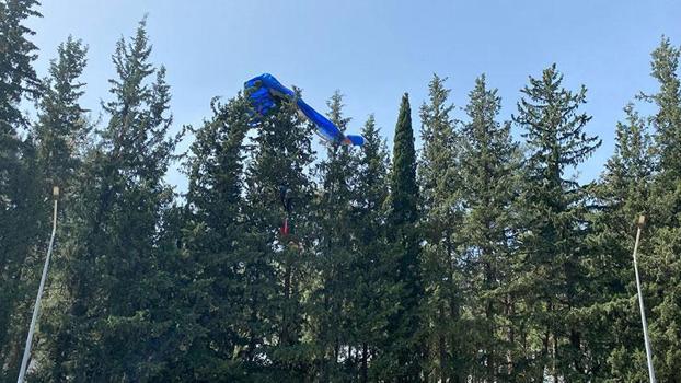 Rüzgar ters esince paraşütü ağaçlara takıldı