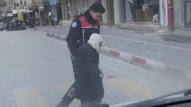 Yolun karşısına geçmekte zorlanan yaşlı kişiye polis yardım etti