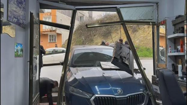 Arnavutköy'de park halinde yokuş aşağı kayan otomobil berber dükkanına daldı