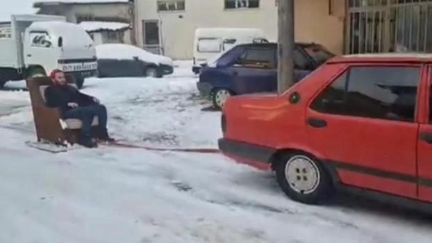 Otomobile bağladığı koltukla kayak yaptı