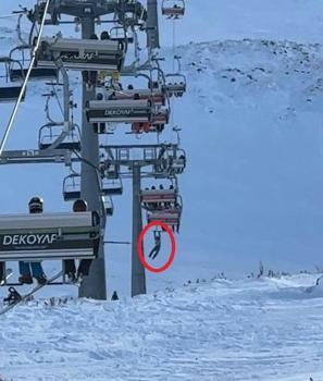 Düşen snowboardını almak için atlamaya çalıştığı telesiyejde asılı kaldı; o anlar kamerada