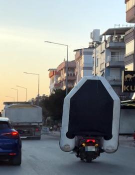 Motosiklet üzerinde şişme botla tehlikeli yolculuk