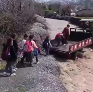 Öğrenciler, debisi yükselen dereyi traktörle geçti