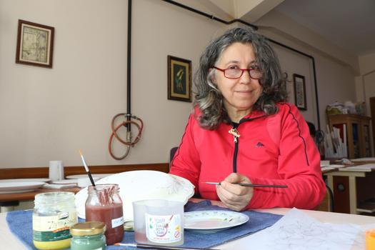 Kazanın izlerini çini fırçasıyla siliyor