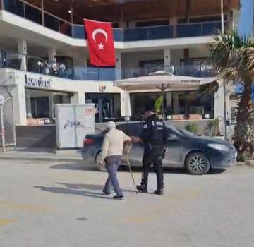 Hatay’da polisin, yolun karşısına geçmekte zorlanan kişiye yardım ettiği anlar kamerada