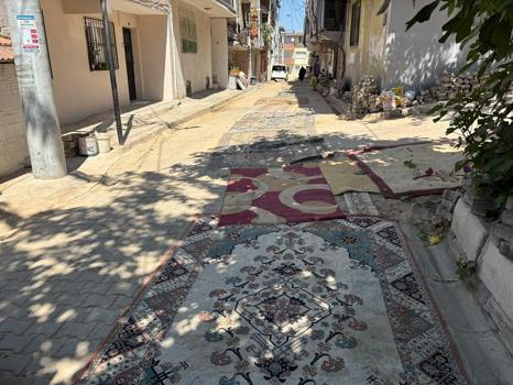 Mahalleli tozdan korunmak için onarılmayan yollara halı serdi
