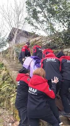 Heyelan nedeniyle yolu kapanan köyüne gitmek isteyen kadını sedyeyle taşıdılar