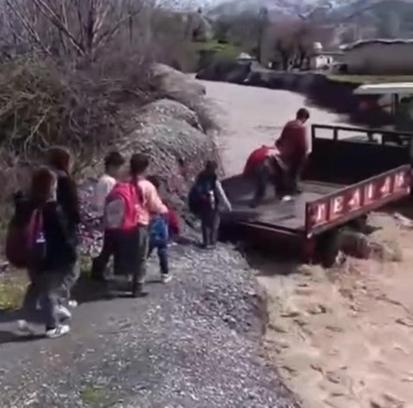 Öğrenciler, debisi yükselen dereyi traktörle geçti