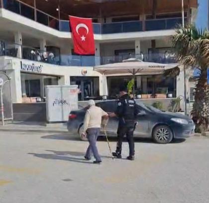 Hatay’da polisin, yolun karşısına geçmekte zorlanan kişiye yardım ettiği anlar kamerada