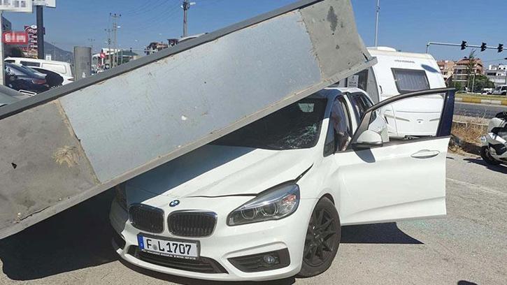 Üzerine reklam totemi devrilen otomobilin sürücüsü yara almadan kurtuldu