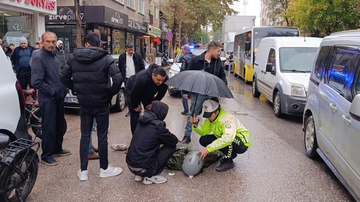 Kadın polis, yaralı ıslanmasın diye başında şemsiyeyle bekledi
