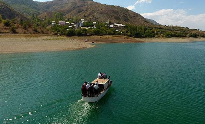 Yolu baraj gölü altında kalan köye kayıkla ulaşım sağlıyorlar