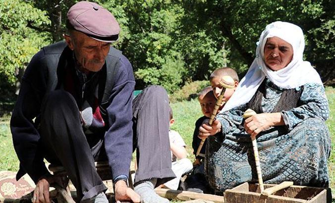 Eski usul tezgahta ceviz ağacından satranç taşı yapıyor