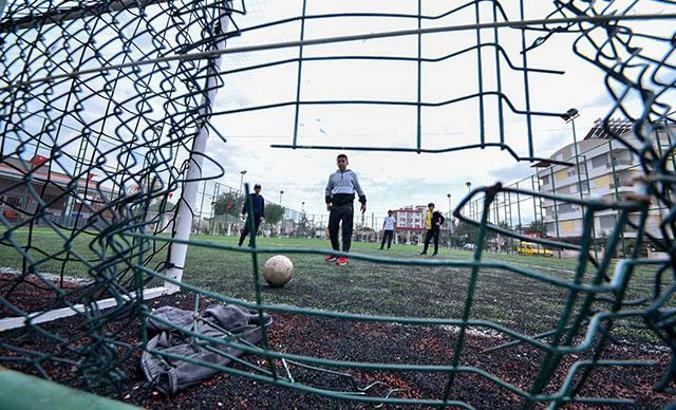 Halı sahalar kapalı ancak çocuklar tel örgüler arasından girip futbol oynuyor