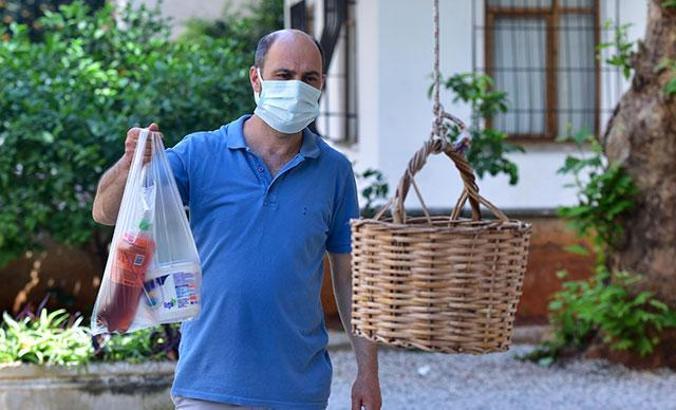 1 yıldır siparişleri balkondan sarkıtılan sepete dolduruyor