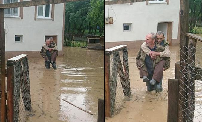 Su basan evde mahsur kalan görme engelli komşusunu sırtında taşıdı