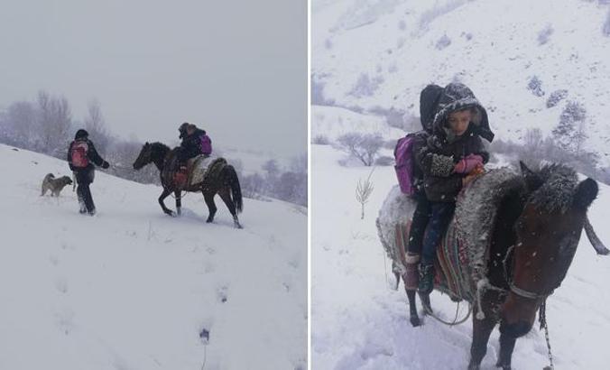 Kar yolu kapatınca, çocukları at sırtında okula götürdü