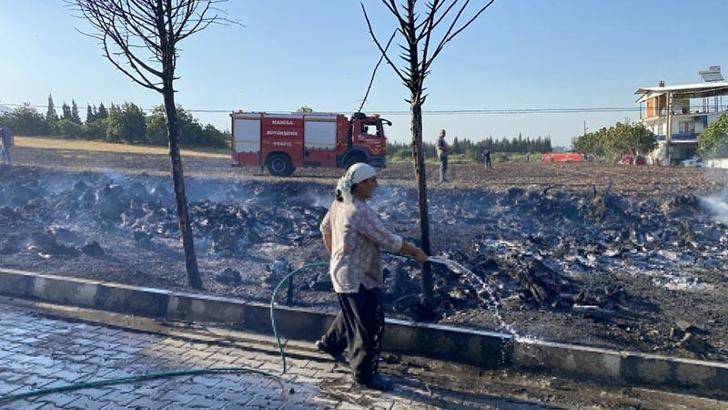 Anız yangınında alevler bahçesine sıçrayınca hortumla müdahale etti