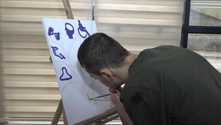 Kelebek hastalığından iki elini kaybeden Ömer, kollarıyla resim yapıyor