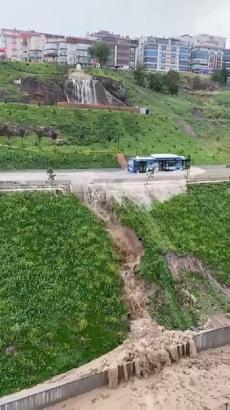 Otobüs göle dönen yoldan geçti, beton bariyeri yıkan su evlere hasar verdi; o anlar kamerada