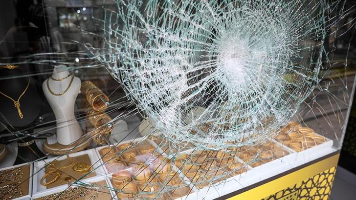 Soyguncunun kaldırım taşıyla kırmaya çalıştığı cam, kurşungeçirmez çıktı