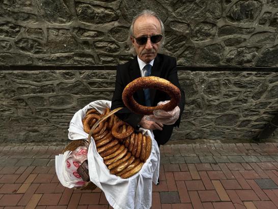 ‘Kravatlı simitçi’ takım elbisesi ve boyalı kunduralarıyla tarihi çarşıları dolaşıp simit satıyor