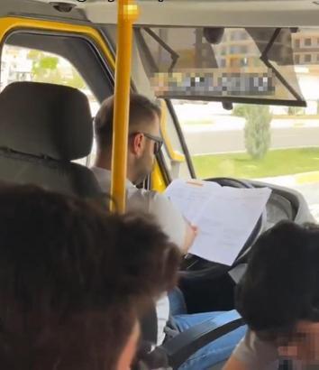 Minibüs şoförü, direksiyonda kitap okurken görüntülendi