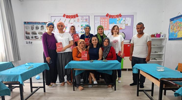 Veliler, çocuklarının sırasında kitap okuyor