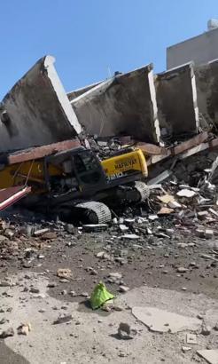 Hatay'da yıkım sırasında 7 katlı bina, iş makinesinin üzerine devrildi
