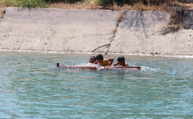 Adana’da sıcakta bunalan çocukların kanalda eski koltukla tehlikeli eğlencesi