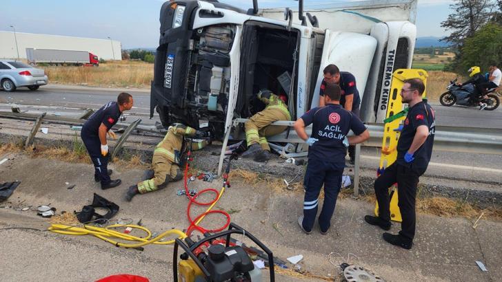Bursa'da karşı şeride geçip devrilen domates püresi yüklü kamyonun şoförü yaralandı
