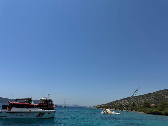 Bodrum'da kayalıklara sürttükten sonra karaya oturan yelkenli için kurtarma çalışması
