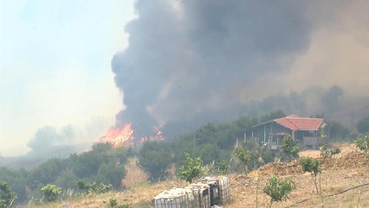 Üzerlerine ilerleyen alevlere rağmen yangının eve sıçramasını engellediler; o anlar kamerada