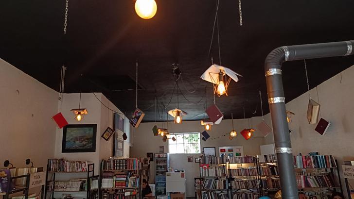 Kitapları, dijital çağa yenilmesine dikkat çekmek için kafenin tavanına astı