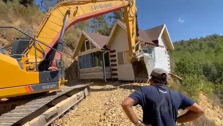 Yıkım kararı verilen konteyner evini iş makinesiyle karadan rayla yürütüp taşıdı