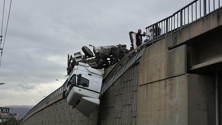 Devrilen TIR'ın kupası viyadükte asılı kaldı; şoförü yaralandı
