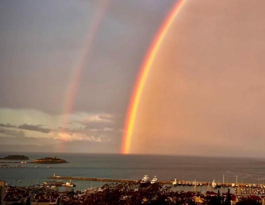 Kuşadası’nda yağmur sonrası denizin üzerinde gökkuşağı oluştu