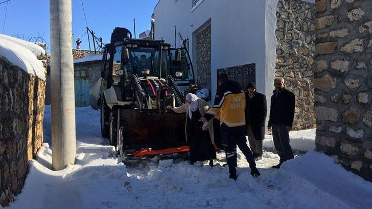 Kardan yolu kapanan mahallede hastalanan kadın, kepçeyle ambulansa taşındı