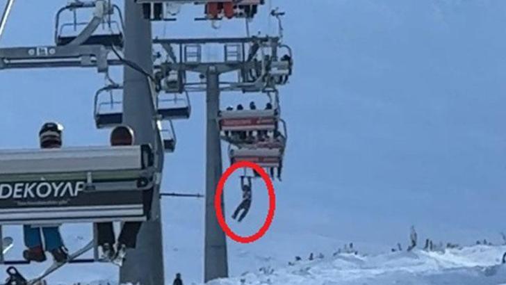 Düşen snowboardını almak için atlamaya çalıştığı telesiyejde asılı kaldı; o anlar kamerada