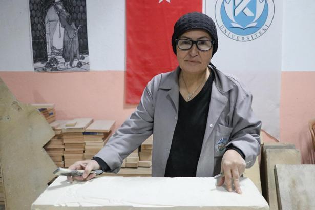 Hat sanatı hocası, tarihi Rum Yetimhanesi'nin bahçesinde kurulan atölyede taşa şekil veriyor
