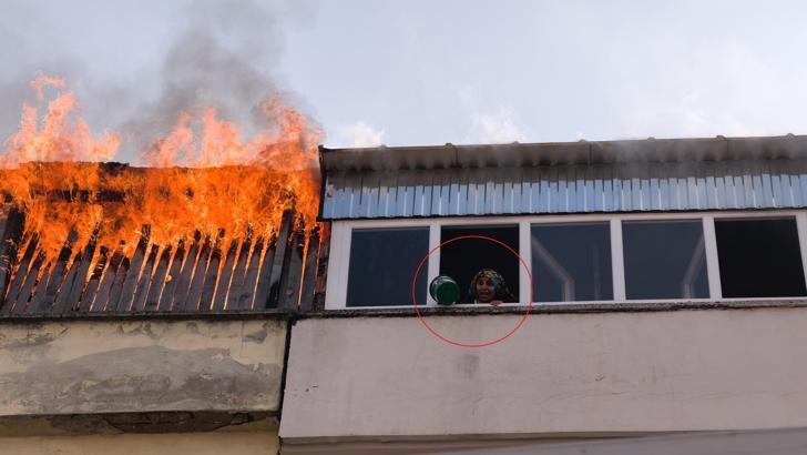 Teras katta yangın çıktı; bitişik binadaki kadın, kova ile pencereye çıkıp yardım istedi