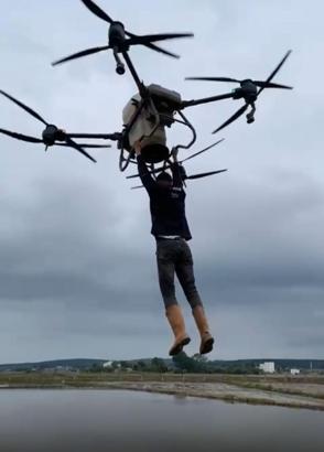 Çiftçi, drona tutunarak tarlanın diğer tarafına geçti