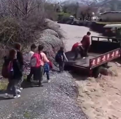 Öğrenciler, debisi yükselen dereyi traktörle geçti