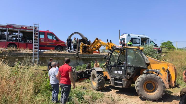 Köprüden düşen traktörün altında kalan sürücü iş makinesiyle kurtarıldı